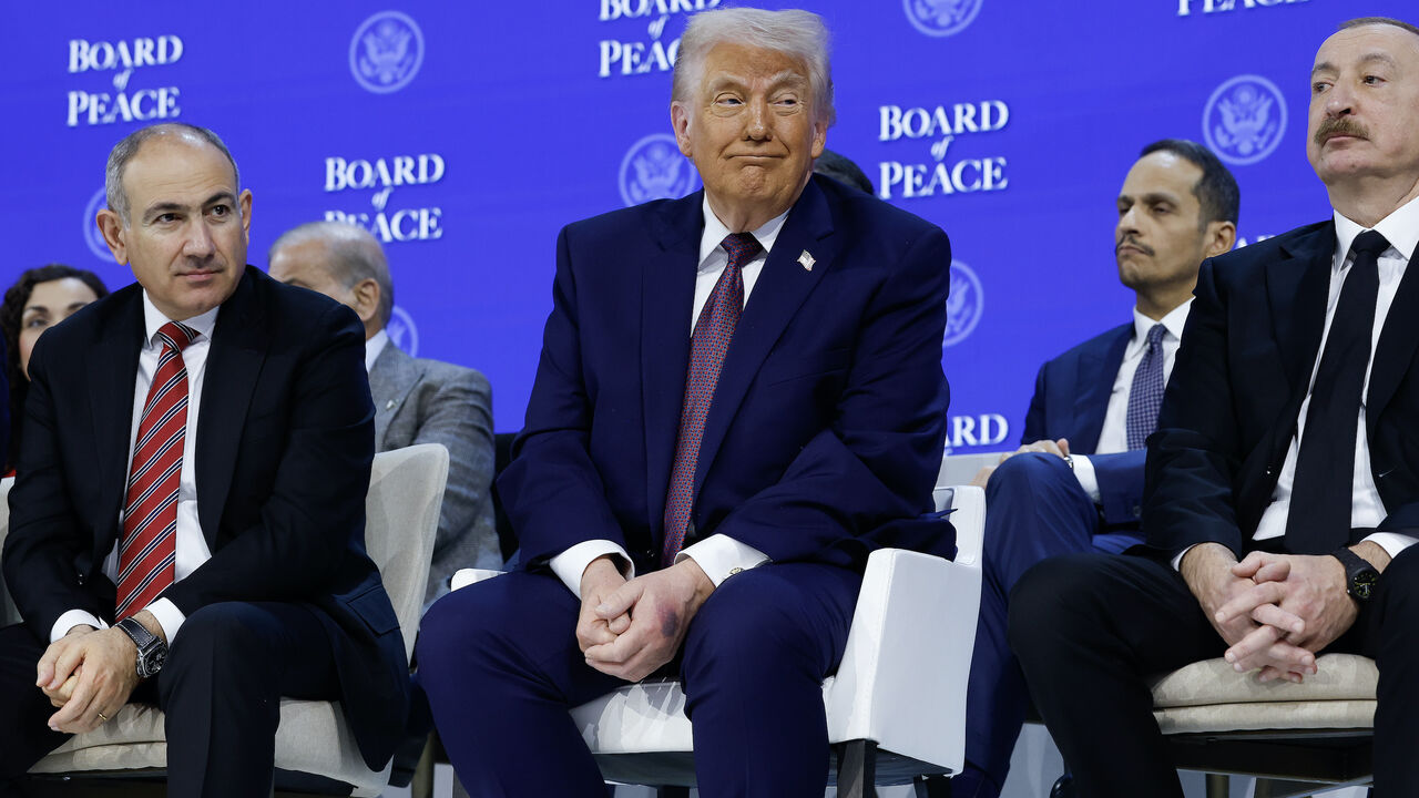 DAVOS, SWITZERLAND - JANUARY 22: U.S. President Donald Trump (C) sits in between Prime Minister of Armenia Nikol Pashinyan (L) and Azerbaijan President Ilham Aliyev during a signing ceremony for the “Board of Peace” at the World Economic Forum (WEF) on January 22, 2026 in Davos, Switzerland. The US-backed “Board of Peace” is intended to administer the fragile ceasefire in the Gaza Strip after the war between Israel and Hamas. The final makeup of the board has not been confirmed. (Photo by Chip Somodevilla/G