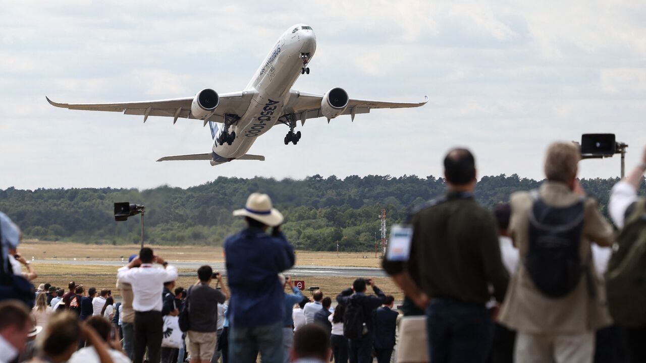 Spectators look on as an A350-1000 by the European plane maker Airbus takes off on the second day of the Farnborough International Airshow 2026, Farnborough, July 21, 2026.