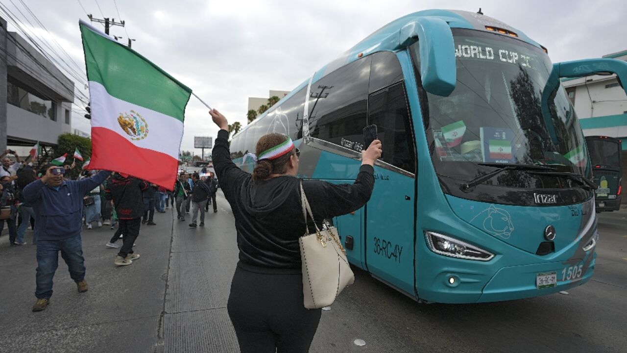 Fans cheer for Iran's World Cup team as they leave their base camp in Tijuana, Mexico
