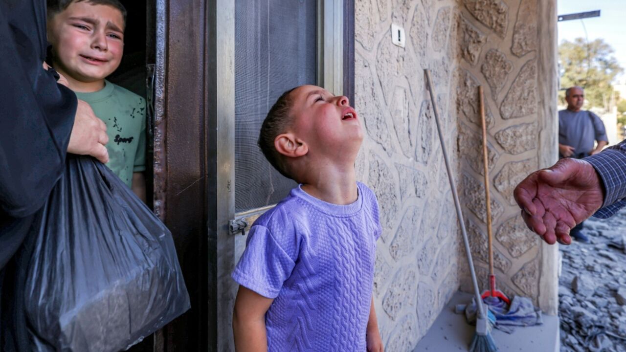 Child relatives of Palestinian Farouk Ramadan, who was involved and killed in clashes with Israeli settlers on July 24, watch after the controlled-demolition of his former apartment the village of Tell in the occupied West Bank