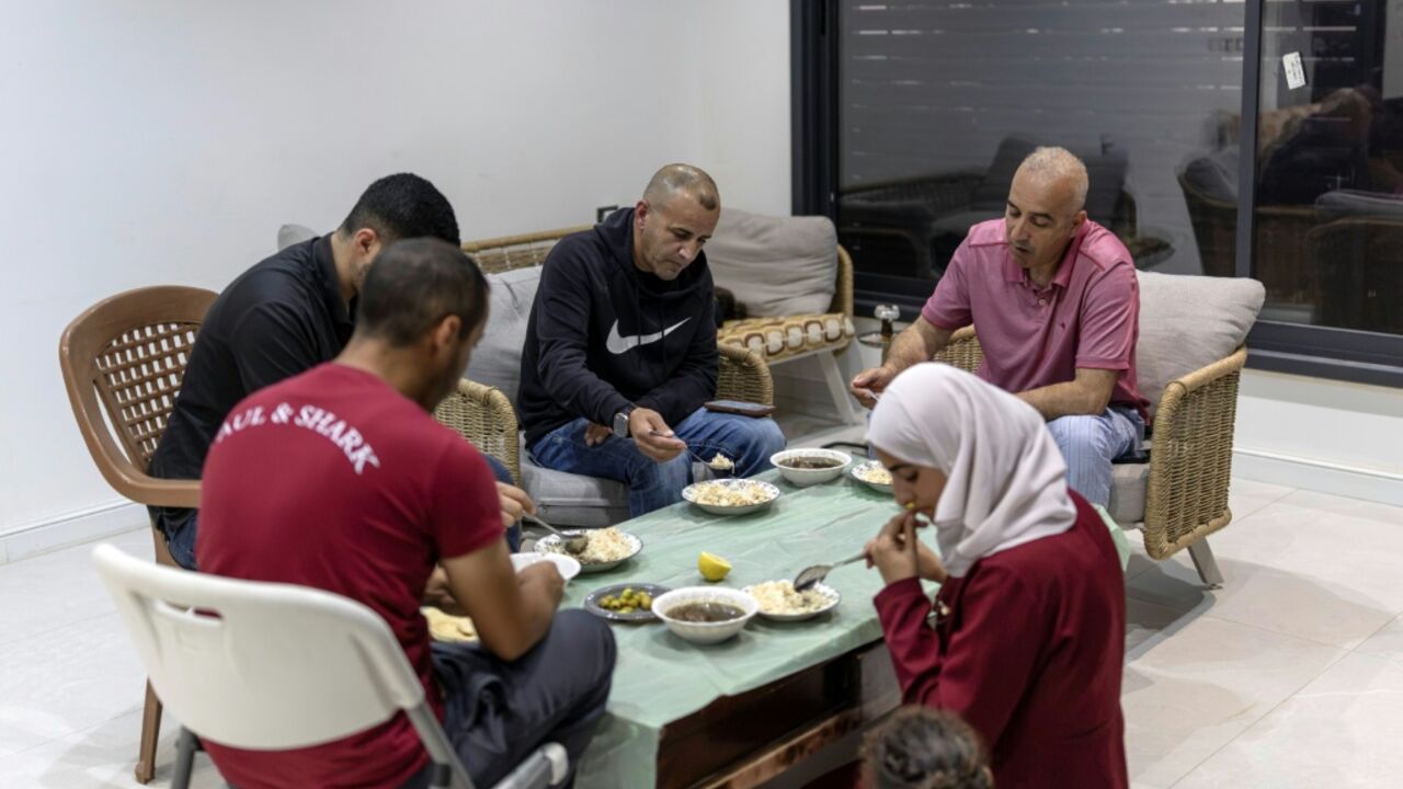 US-Palestinian dual citizen Louai Abu Ridi (C), whose home in the occupied West Bank village of Qusra is besieged by Israeli settlers, shares an evening meal with family members at the home in Qusra