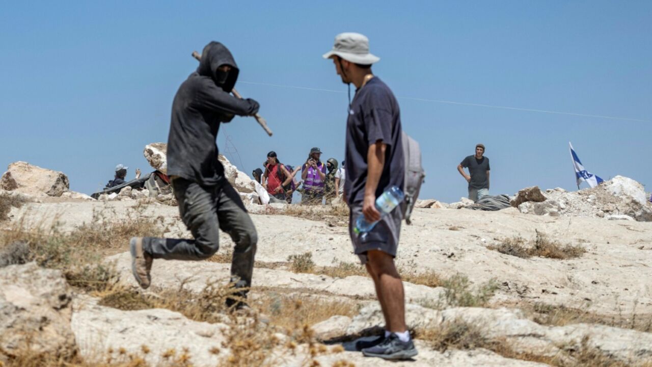 An Israeli settler attacks a left-wing activist who came to protect Palestinians at the illegal Israeli outpost of Jannatah