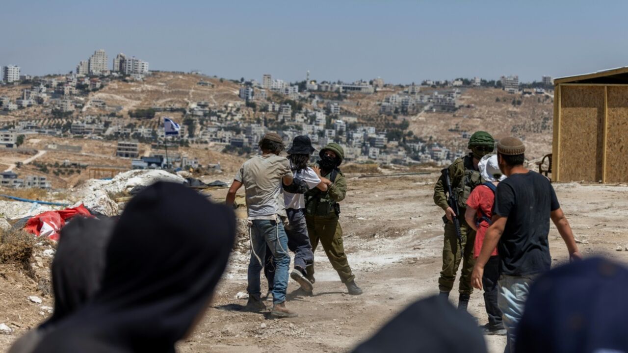 Israeli left-wing activists and Israeli settlers scuffle as Israeli security intervenes at an Israeli outpost in the Palestinian village of Jannatah, just south of the city of Bethlehem in the occupied West Bank