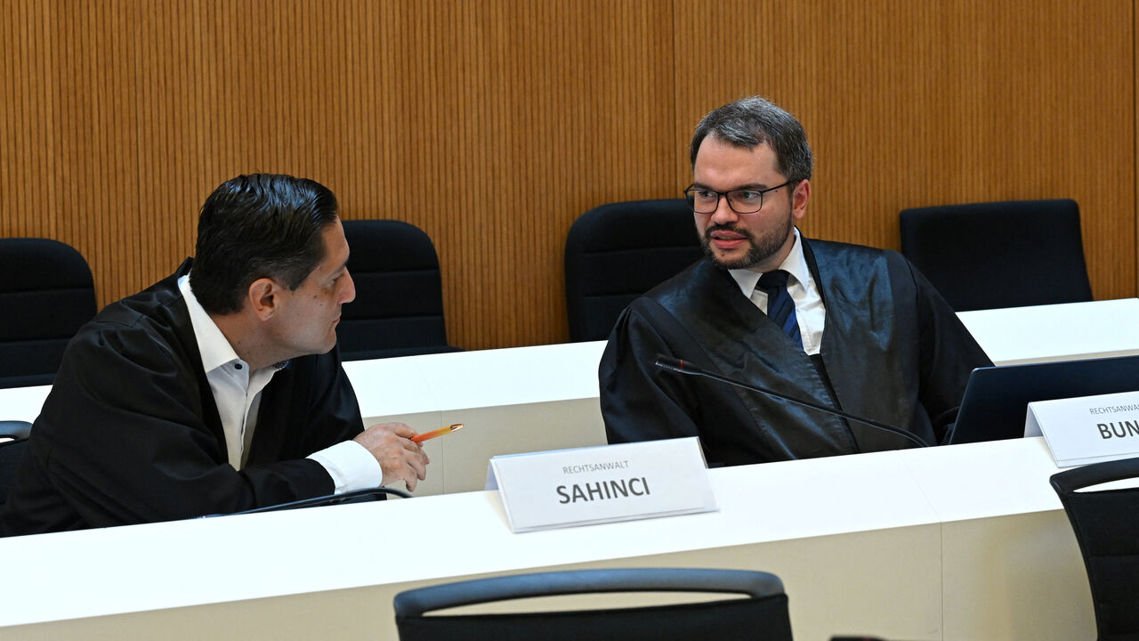 Attorneys Oemer Sahinci and Johann Bund represent defendant Farhad N., accused of murder and other charges, as he arrives for his verdict in a courtroom in Munich, Germany, August 6, 2026. REUTERS/Angelika Warmuth
