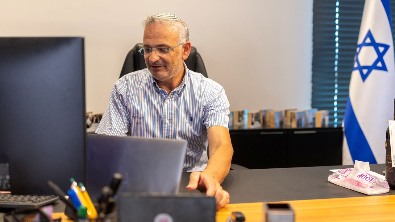 Shai Alon, the Head of the Beit El Municipal Council uses his computer in his office in the Israeli settlement of Beit El in the Israeli-occupied West Bank. July 22, 2026. REUTERS/Ronen Zvulun