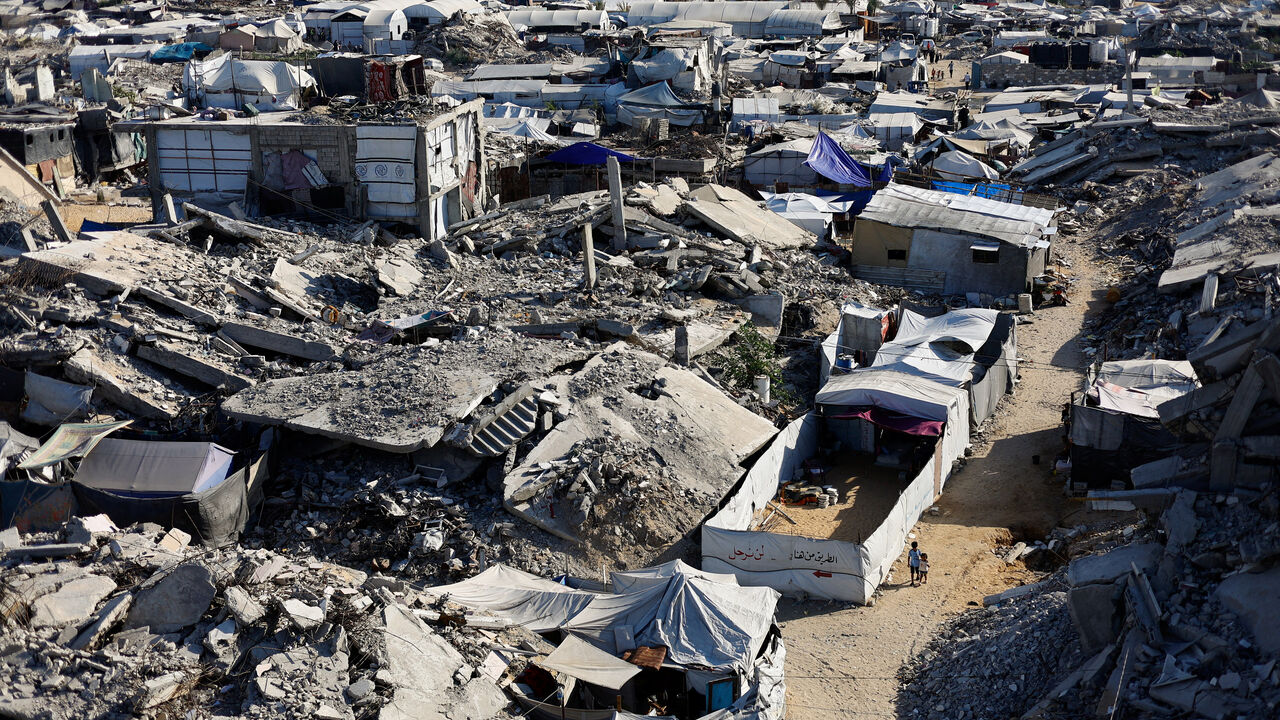 Palestinian children walk past the rubble of residential buildings destroyed during the war, at Jabalia refugee camp in the northern Gaza Strip, August 5, 2026. REUTERS/Mahmoud Issa
