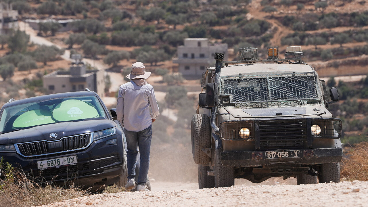 An Israeli army vehicle stands near a Palestinian house which was besieged by Israeli settlers in Qusra village in the Israeli-occupied West Bank, August 13,2026. REUTERS/Ali Sawafta