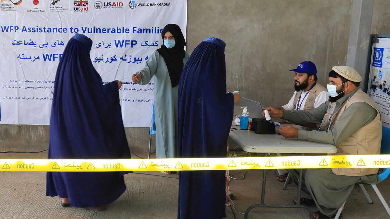 FILE PHOTO: Afghan women arrive to receive assistance from a World Food Program (WFP) distribution centre in Kabul, Afghanistan, August 21, 2024. REUTERS/Sayed Hassib/File Photo