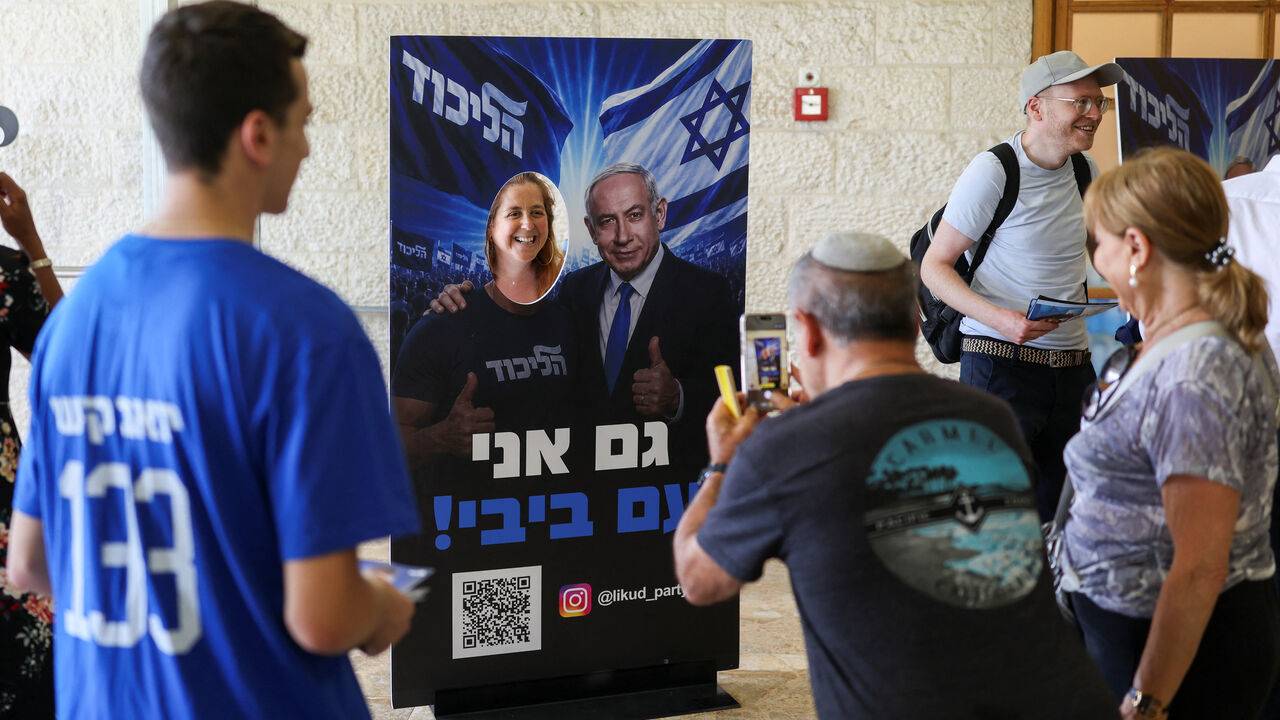 A woman poses with a photo stand-in featuring an image of Israeli Prime Minister Benjamin Netanyahu, on the day of the Likud party primaries list vote, ahead of Israel's general election in October, in Jerusalem, August 17, 2026. REUTERS/Ronen Zvulun