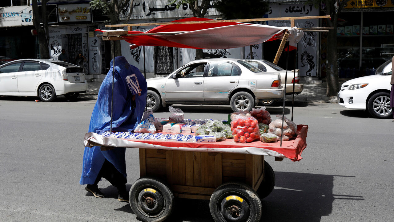 FILE PHOTO: An Afghan woman pushes her cart in Kabul, Afghanistan, July 6, 2023. REUTERS/Ali Khara/ File Photo
