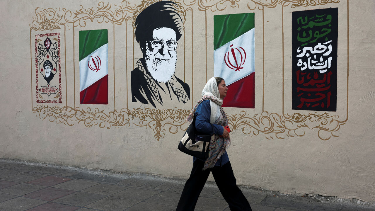 A woman walks by a mural depicting Iran's late Supreme Leader Ayatollah Ali Khamenei, on a street in Tehran, Iran, August 13, 2026. Majid Asgaripour/WANA (West Asia News Agency) via REUTERS