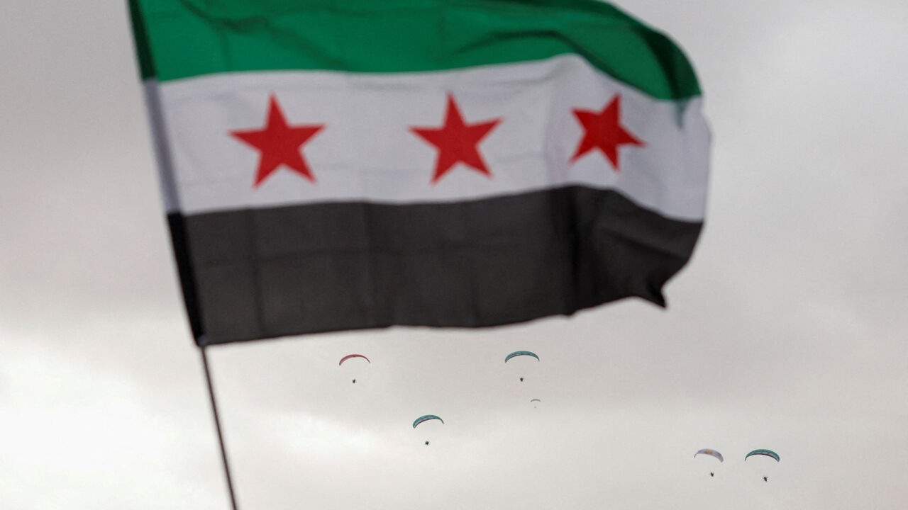 A flag flies in the wind at Ummayad Square in Damascus, Syria December 8, 2025. REUTERS/Yamam al Shaar