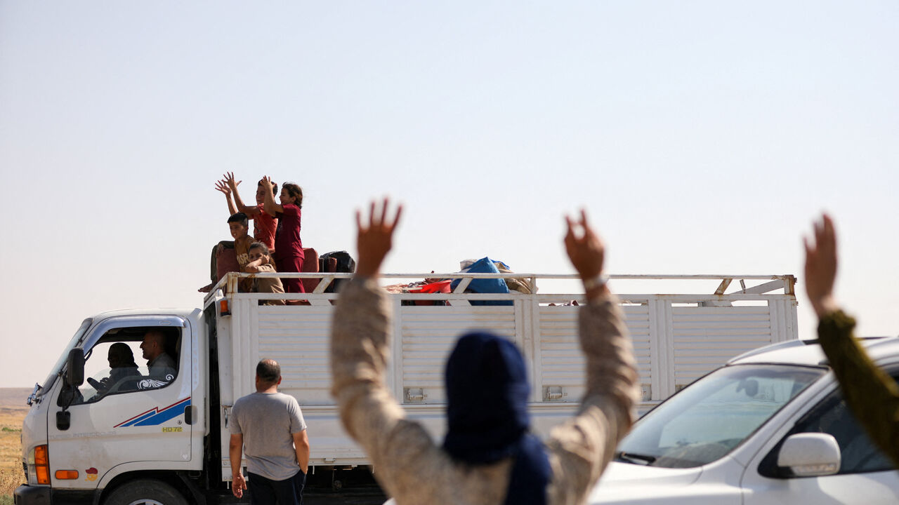 People wave to Kurds displaced during Syria's civil war who make their way to their hometown of Ras al-Ain (Sere Kaniye) under a January 2026 agreement between the Syrian Democratic Forces (SDF) and the Syrian government, in Hasakah, Syria, August 10, 2026. REUTERS/Orhan Qereman