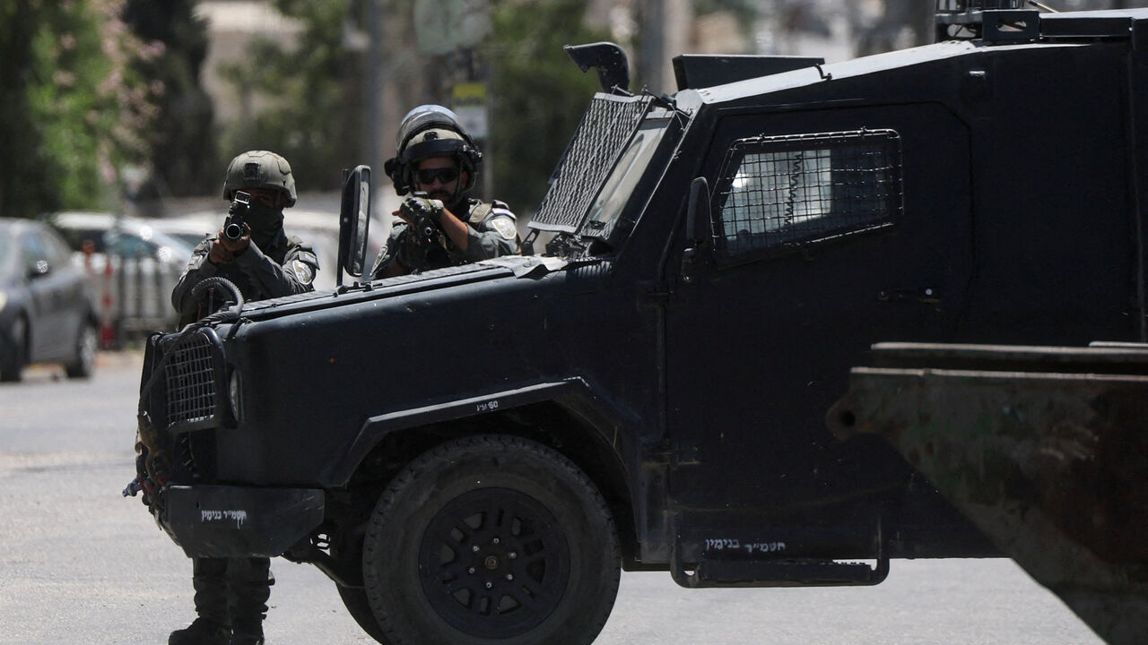 FILE PHOTO: Israeli forces point their weapons as they take part in a raid in Qalandia refugee camp, in the Israeli-occupied West Bank, August 25, 2026. REUTERS/Ammar Awad/File Photo
