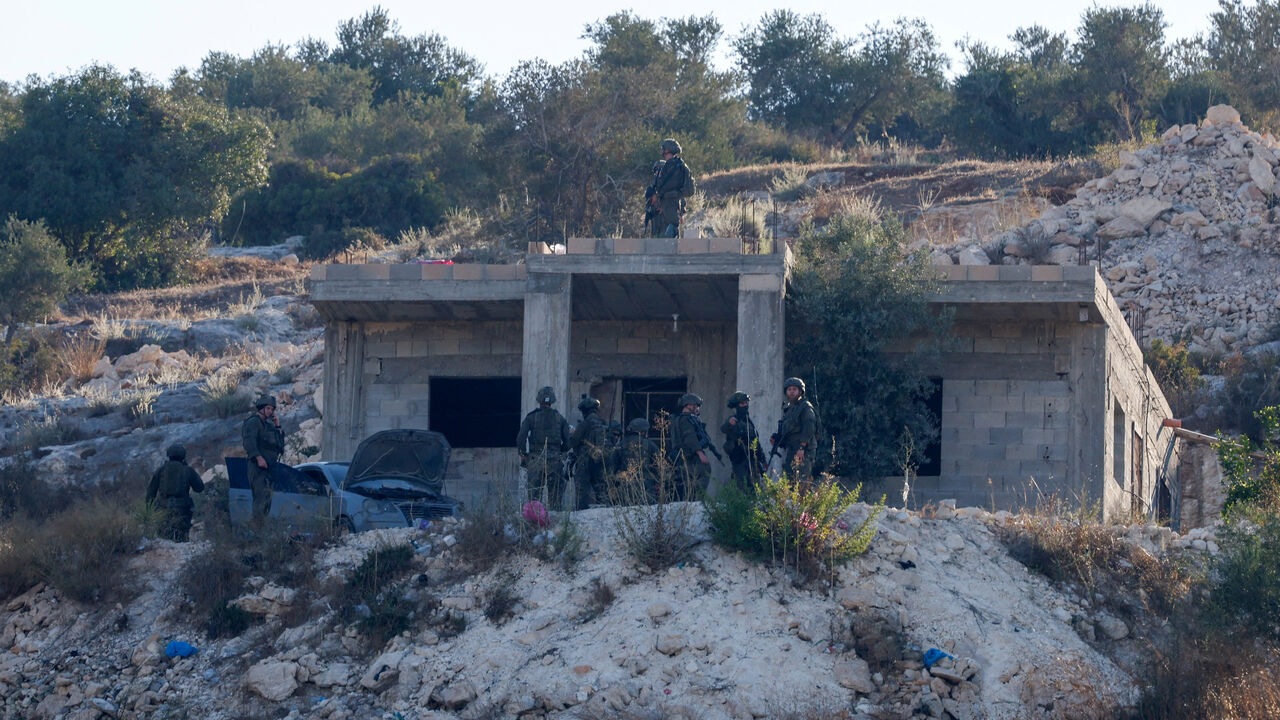Israeli military forces stand by a building, following an Israeli military airstrike, in Jenin, in the Israeli-occupied West Bank, August 28, 2026. REUTERS/Mohammed Torokman