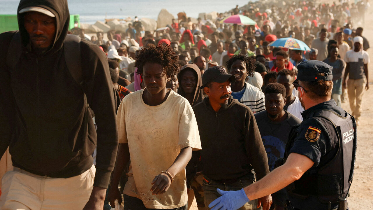 FILE PHOTO: Migrants are escorted from a makeshift beach camp to official shelters across the city after authorities cleared the site, following a mass crossing from Morocco, in Spain's North African enclave of Ceuta, August 20, 2026. REUTERS/Violeta Santos Moura/File Photo