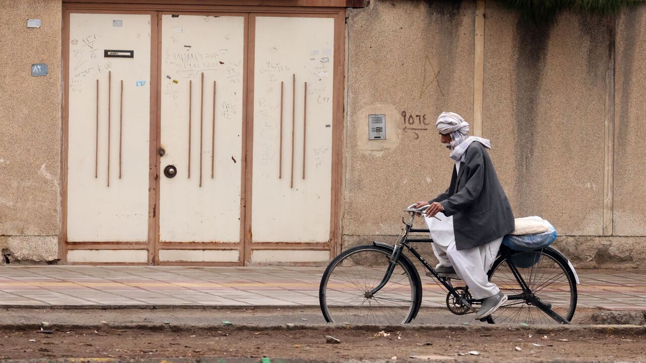 A Baluch Iranian man rides a bicycle