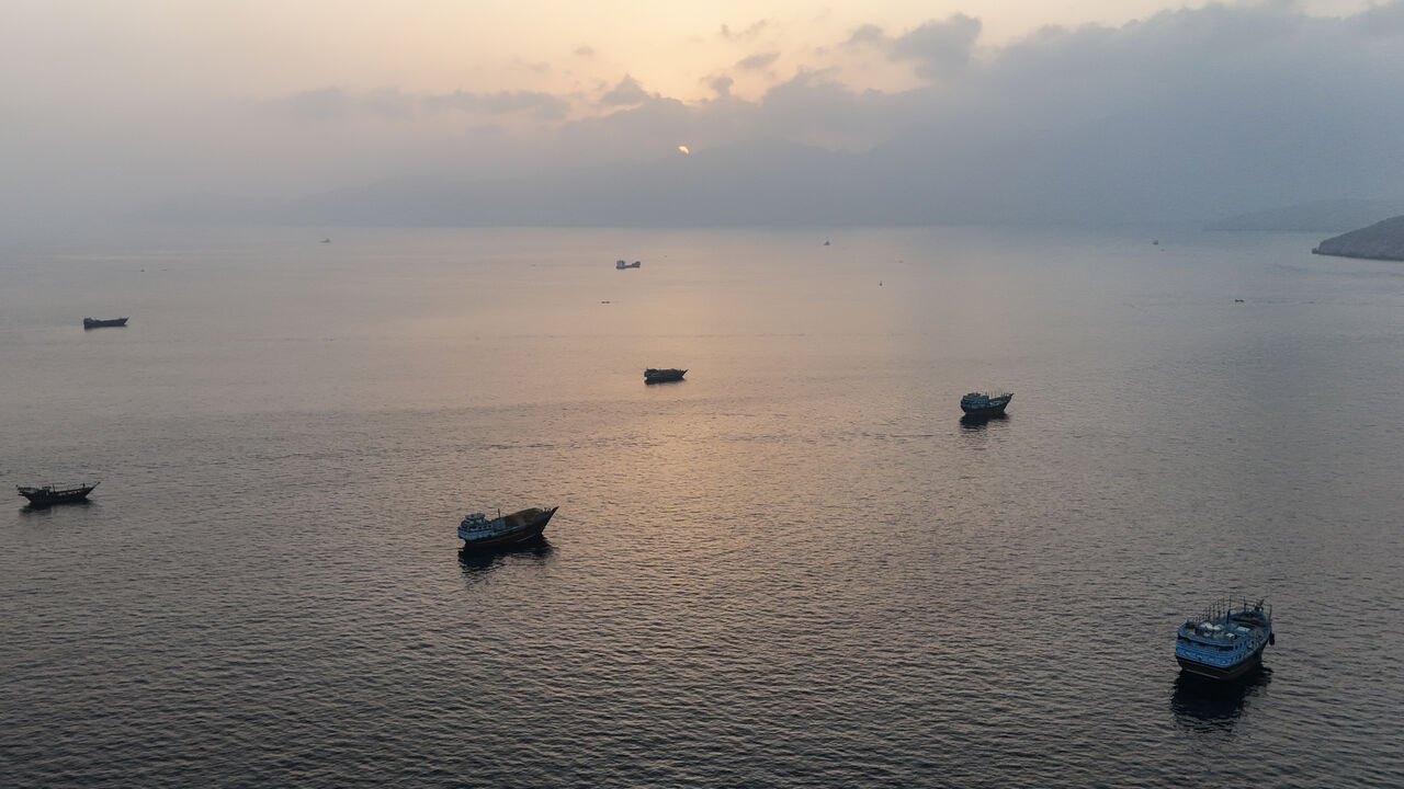 TOPSHOT - This aerial photograph shows boats anchored off Oman's northern Musandam Peninsula near the Strait of Hormuz on June 27, 2026. Iran launched attacks on US sites in the Gulf in response to American strikes on the country, state media said on June 27, after Washington accused Tehran of attacking one of its cargo ships in the Strait of Hormuz. The trading of fire raised questions about efforts to keep the crucial waterway open while Washington and Tehran negotiate a final settlement to a war that beg