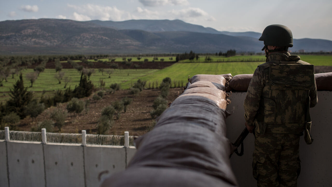 A Turkish soldier from the 1st Border Regiment Command looks out over the border wall to Syria during alert drills at a military outpost on the Turkey/Syria border on March 2, 2017 in Kilis, Turkey. 