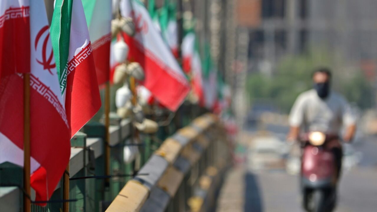 A motorist drives past Iranian flags installed along a street, a day before the funeral procession of Iran's slain supreme leader Ali Khamenei in the holy Iraqi city of Karbala