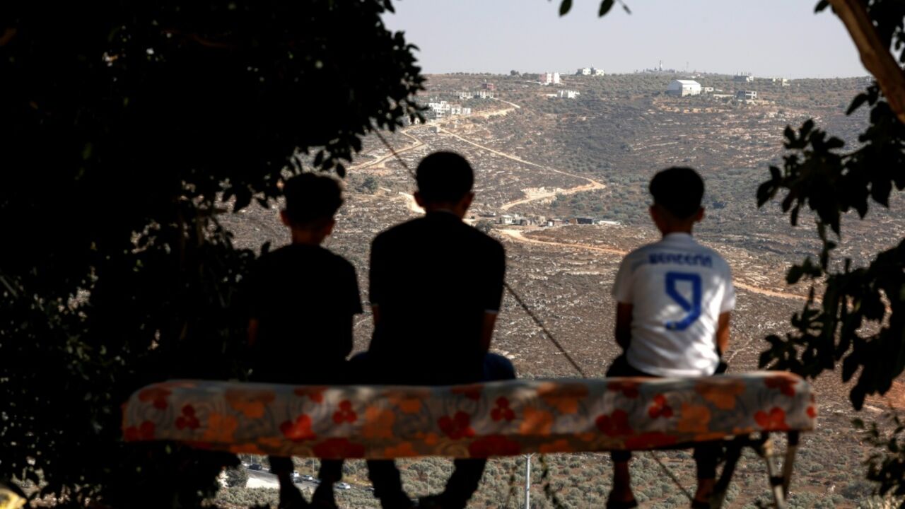 Palestinian boys looking towards a new illegal Israeli outpost in the West Bank