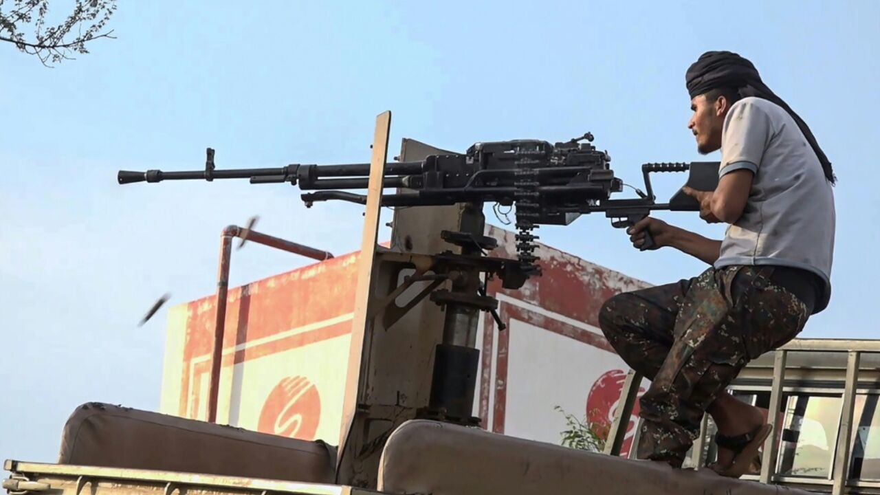 A member of the Saudi-backed Yemeni government forces fires a heavy machine gun during clashes with Houthi fighters in Taiz province