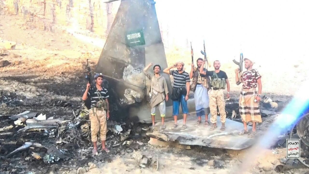 This handout picture released by Ansar Allah Media Centre shows Houthi fighters posing in the midst of what the Iran-backed group said is the wreckage of a Saudi F-15 fighter jet that was shot down in the central province of Marib