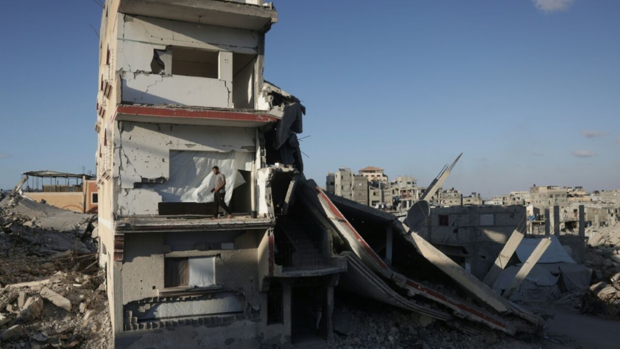 A displaced Palestinian man stands on the balcony of a heavily damaged building still used as shelter in Khan Yunis in the southern Gaza Strip on September 19, 2026