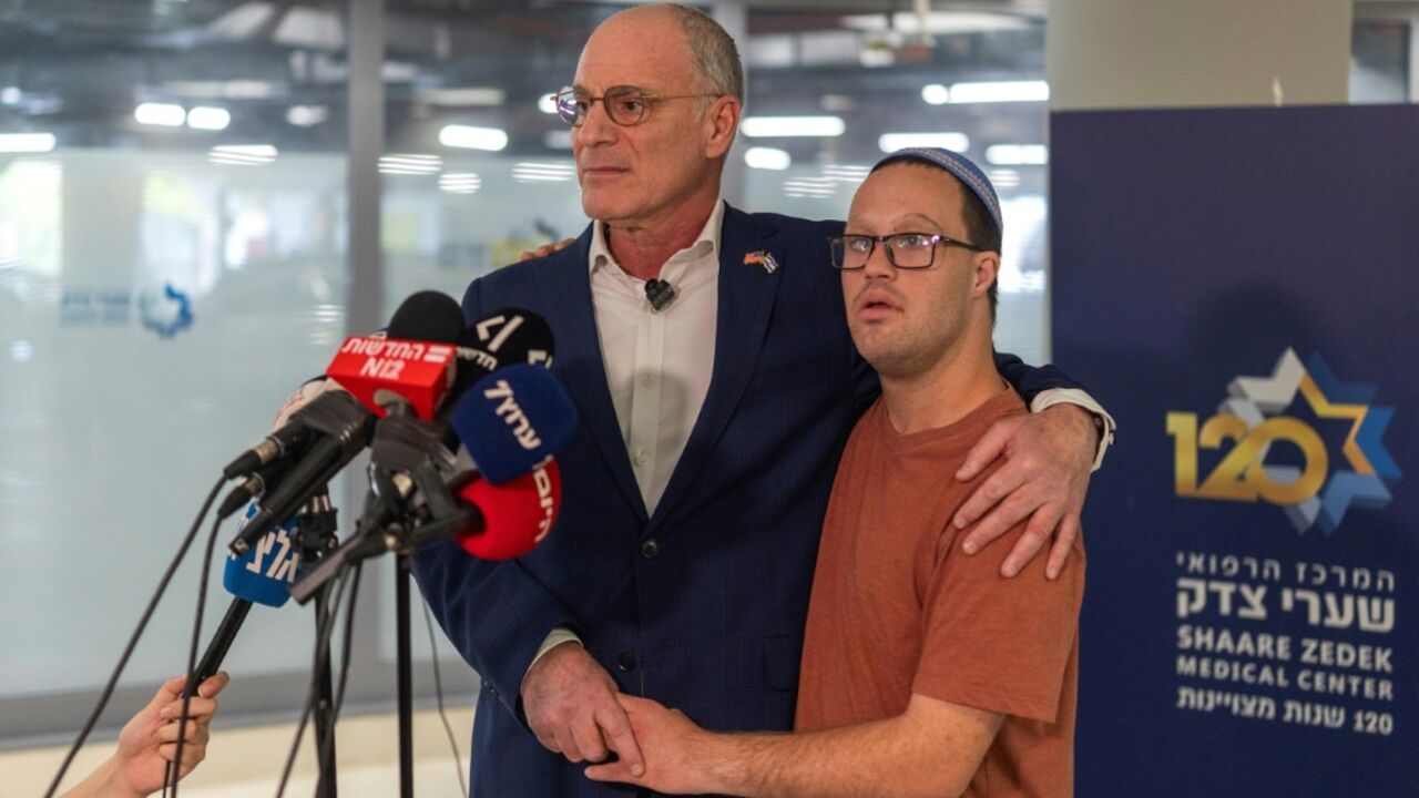 Israeli ambassador to the US Yechiel Leiter stands with his son Noam Leiter while giving a statement to the press at the Shaare Zedek hospital in Jerusalem where his son Neria Leiter was being treated following a car-ramming attack