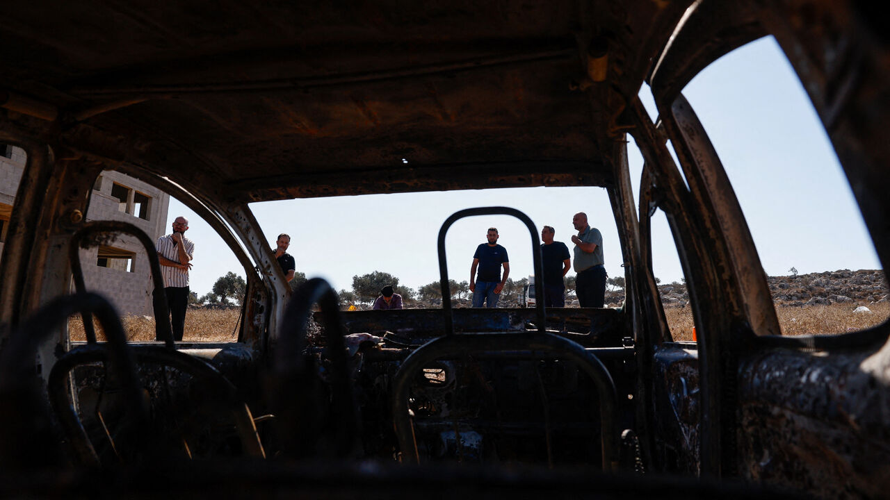 Palestinians stand near a destroyed car, which Palestinians say was burned by Israeli settlers last night, in Beita, near Nablus, in the Israeli-occupied West Bank, September 2, 2026. REUTERS/Mohammed Torokman