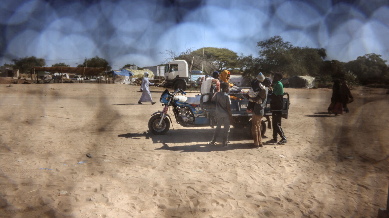 FILE PHOTO: A Sudanese refugee father from Al-Fashir rides on a motorized cart with his family travelling between Chad and Sudan amid the ongoing conflict between the paramilitary Rapid Support Forces (RSF) and the Sudanese army, at the Tine border post in eastern Chad, November 22, 2025. REUTERS/Amr Abdallah Dalsh/File Photo