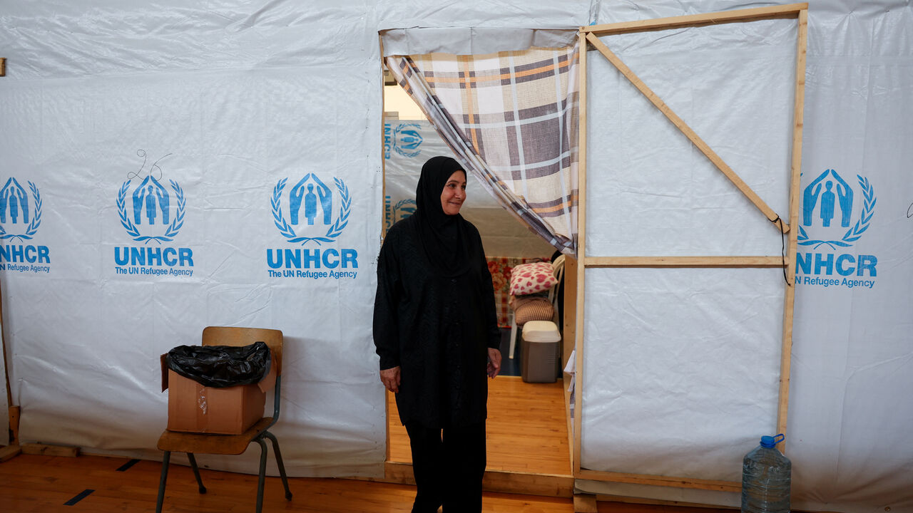 Zeinab Moussa, 56, a displaced mother from southern Lebanon, stands outside her tent in a school turned into a shelter for displaced families in Tyre, southern Lebanon, August 27, 2026. REUTERS/Mohamad Azakir