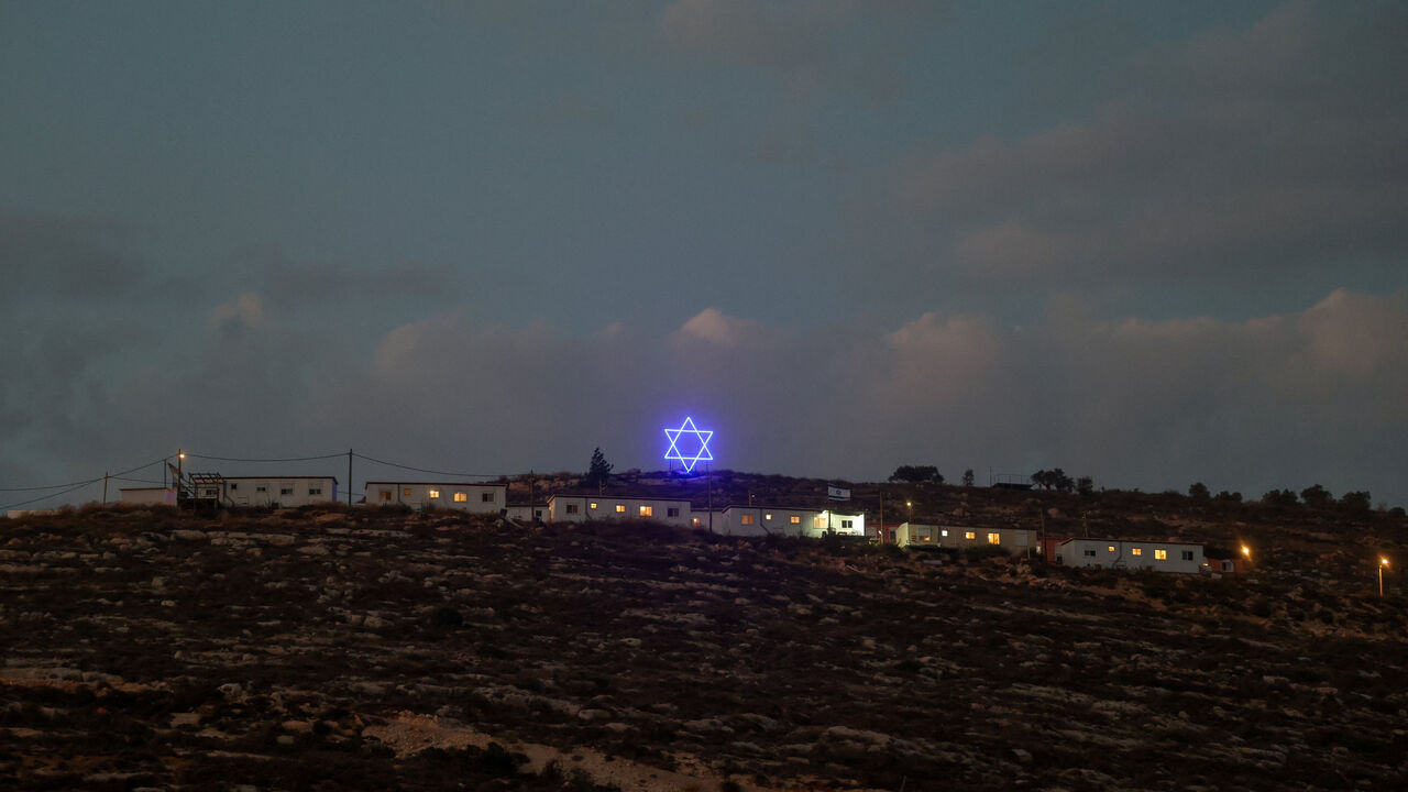 An illuminated Star of David above an Israeli settlers outpost near Ramallah, in the Israeli-occupied West Bank, August 14, 2026. REUTERS/Ammar Awad