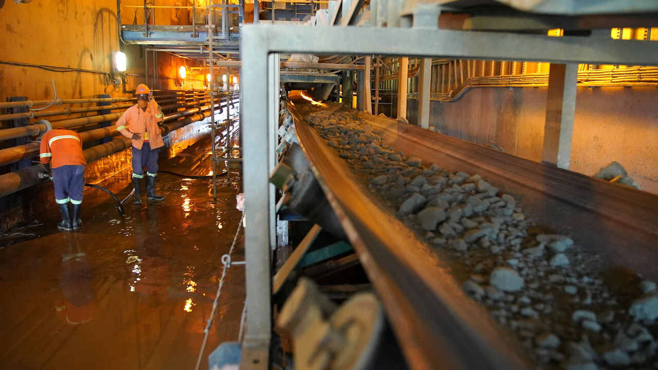FILE PHOTO: Workers mend a pipe as crushed ore is transported on a conveyor belt at the Kibali gold mine Haut-Uele province, Democratic Republic of Congo October 8, 2021 . Picture taken October 8, 2021. REUTERS/Hereward Holland/File Photo