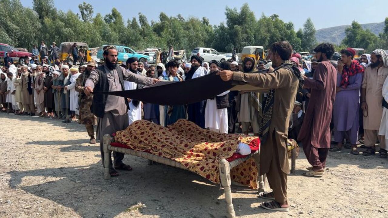 People place a black cloth over the bodies of victims killed in what the Taliban said was a Pakistani airstrike, in Kunar province