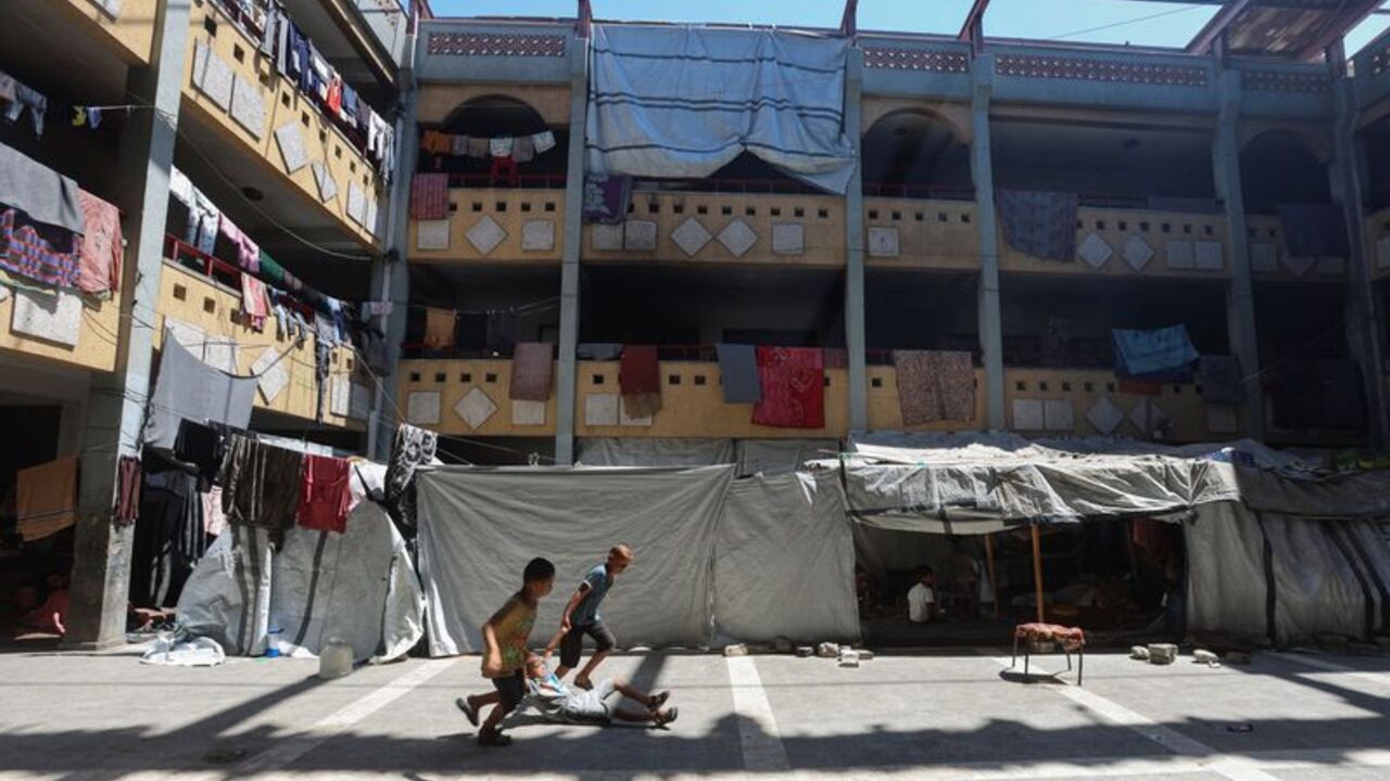 Displaced Palestinian children play inside a school-turned-shelter, in Khan Younis