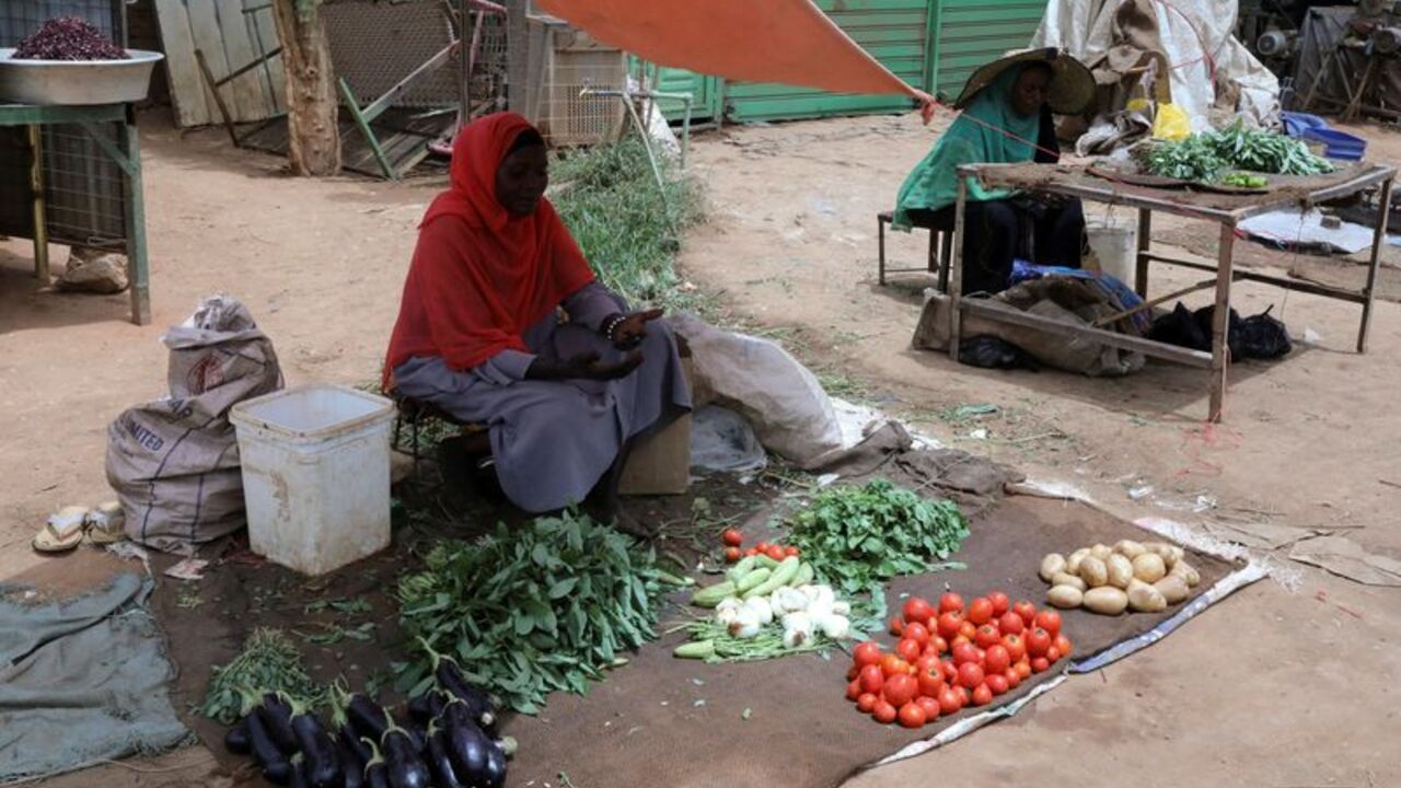 Vegetable vendors wait for customers at a market in Omdurman