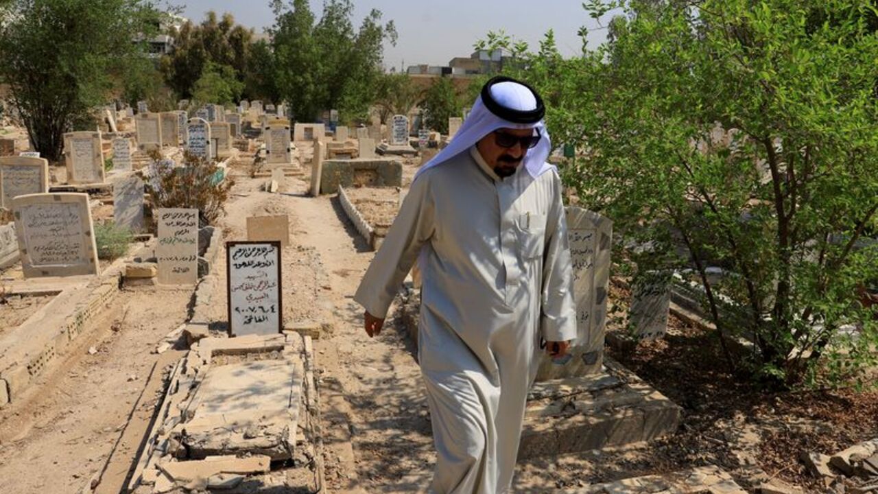 Sunni tribal sheikh Abdul Rahman al-Zobaie walks through the Martyrs' Cemetery in Falluja