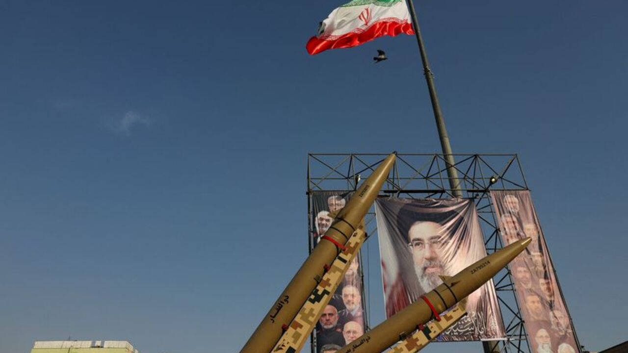 Iranian missiles are displayed next to a banner with a picture of Iran's Supreme Leader, Mojtaba Khamenei, on a street in Tehran