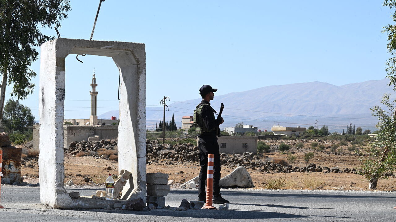 A member of Syria's security forces stands guard outside a former army base near the city of Quneitra in southern Syria, on the edge of the Israeli-annexed Golan Heights on Sept. 21, 2025. 