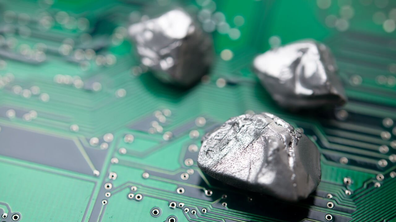 Rare earth mineral on a green electronic circuit board. — Getty Images stock photo