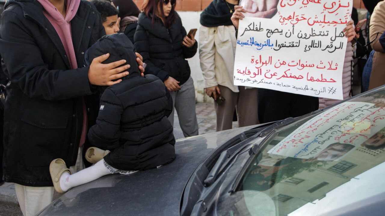 Protesters hold banners calling for child protection and justice