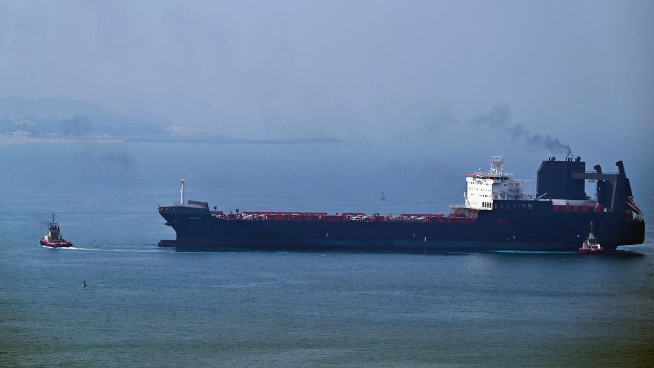 A tugboat guides a ship at the Khor Fakkan Container Terminal, the only natural deep-sea port in the region and one of the major container ports in Sharjah Emirate, along the Gulf of Oman on July 14, 2026.