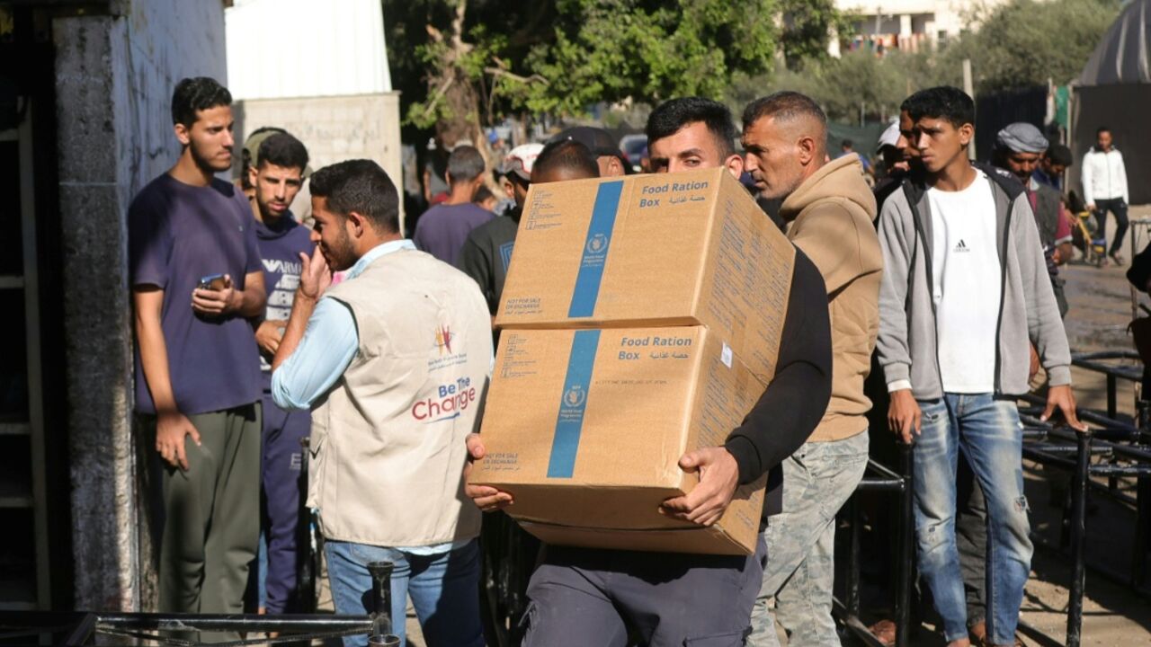 A Palestinian man collects food ration boxes provided by the World Food Programme at a distribution centre in the village of Al-Zawayda in the centre of the Gaza Strip on October 27, 2025