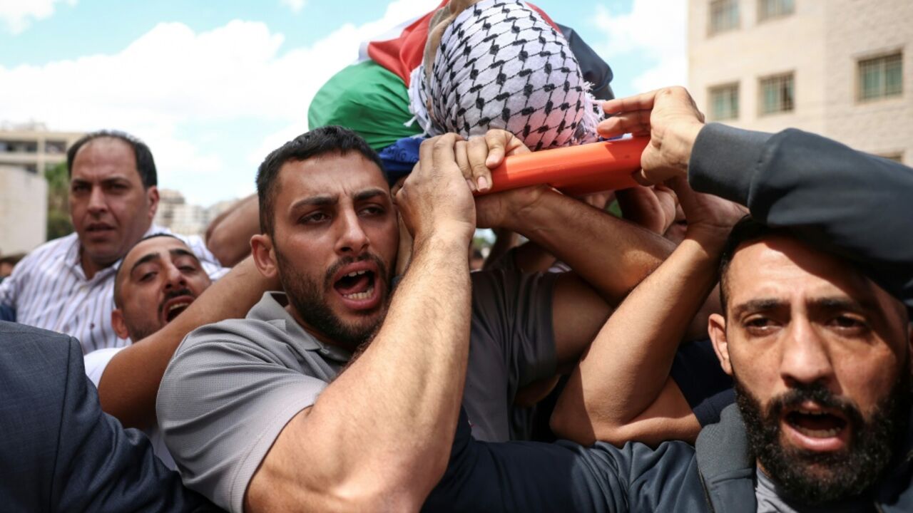 Mourners carry the body of Palestinian man Ali al-Bazzari at Rafidia Hospital in the Israeli-occupied West Bank city of Nablus, after he was reportedly killed in an Israeli settler attack that was followed by army intervention
