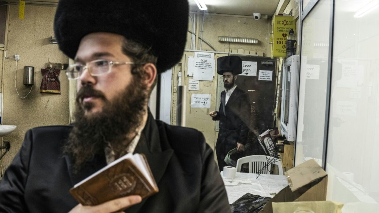 Ultra-Orthodox Jewish men pray in a synagogue in Arad on October 1, 2026. As Israelis prepare to vote in parliamentary elections on October 27, tensions in Arad have become a microcosm of a broader national debate.
