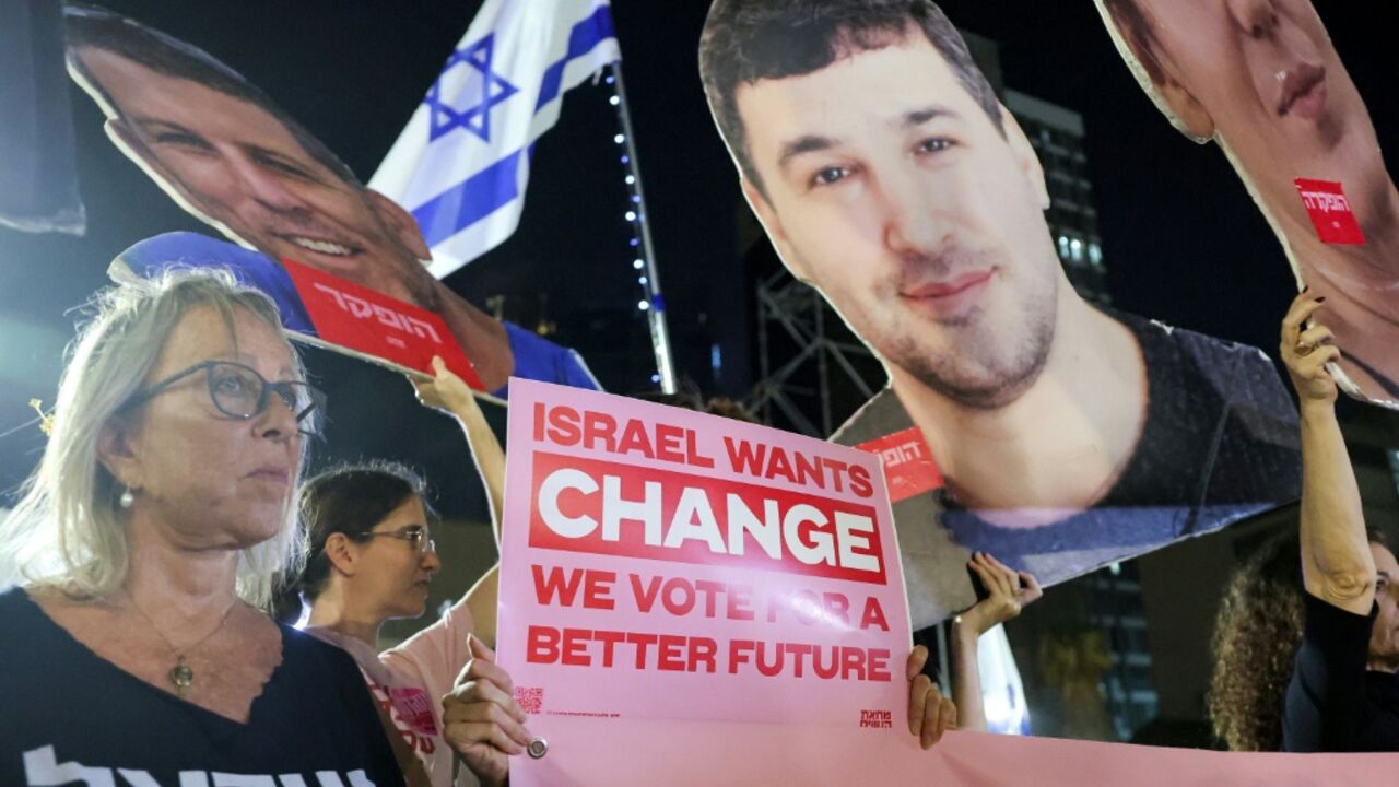 Protesters gather with signs during an anti-government demonstration demanding the formation of a state commission of enquiry into Hamas's October 7, 2023 attack at Hostages Square in Tel Aviv