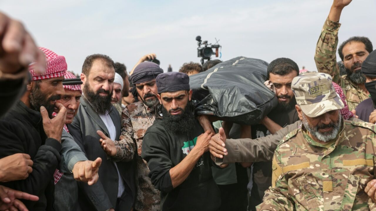 Mourners carry the bodies of those killed in airstrikes carried out by Jordan the night before