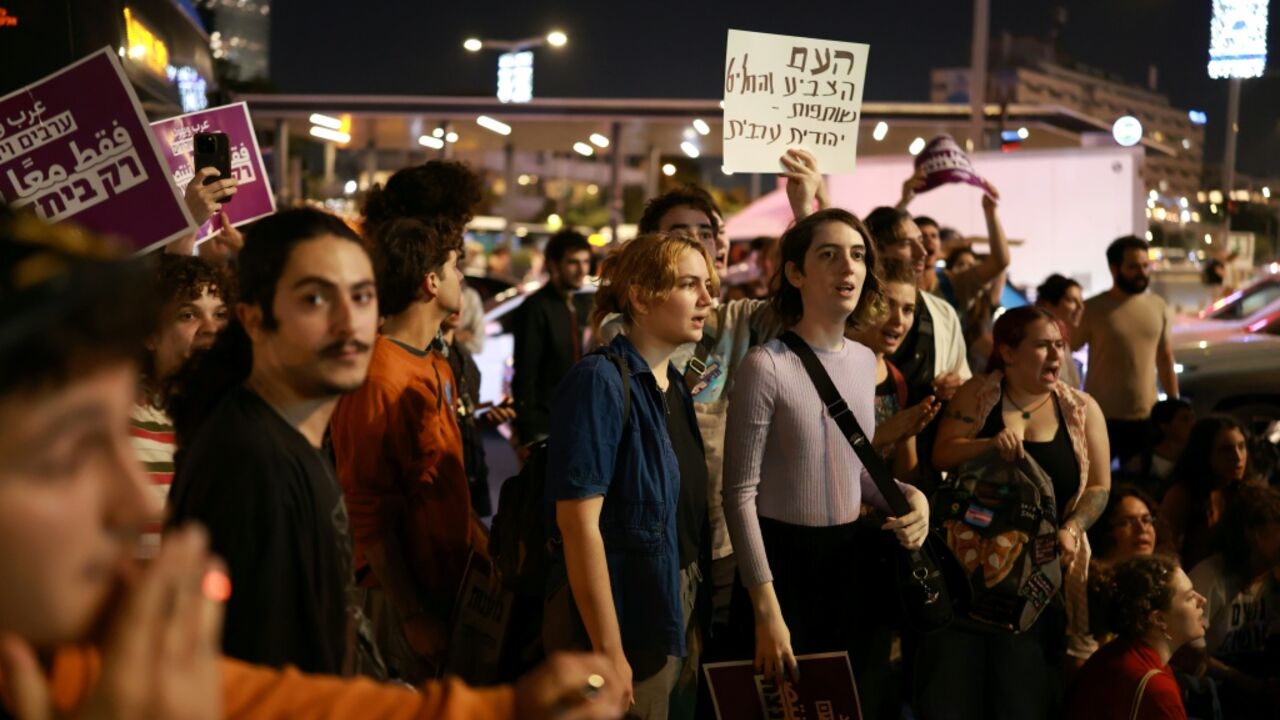 Israeli left-wing activists in Tel Aviv hold placards during a protest calling for a formation of a government together with Arab parties