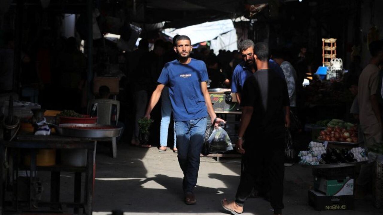 Palestinians walk through a street market in Gaza
